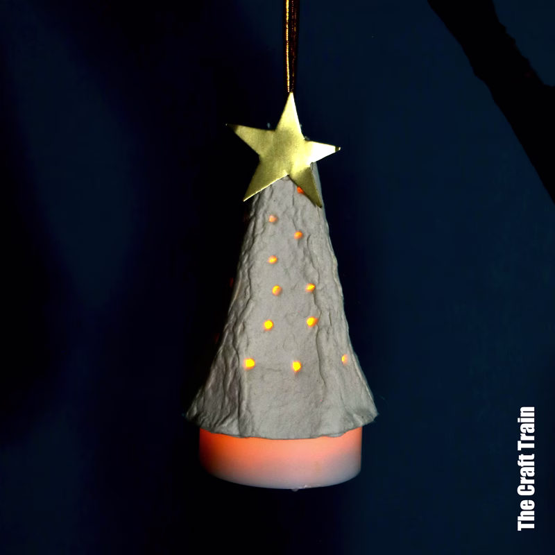 egg carton Christmas tree ornament with LED candle and gold star, lit up in the dark
