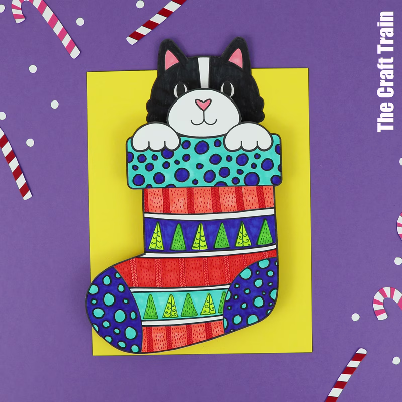 Kids printable art project featuring a black and white kitten peeking out of pattern art Christmas stockings