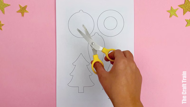 Steps to make cardboard shape decorations. Cut out the Christmas shapes from our printable template