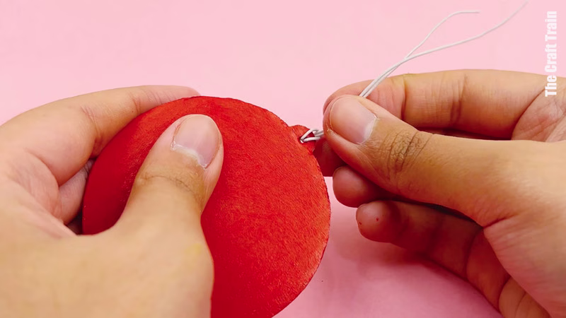 Steps to make cardboard shape decorations. Thread string through the hole, then thread with coloured beads.