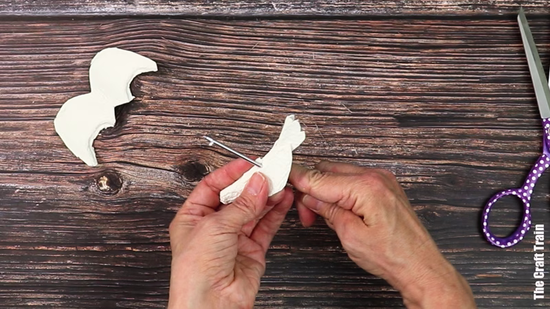Hands showing how to make an egg carton peace dove ornament