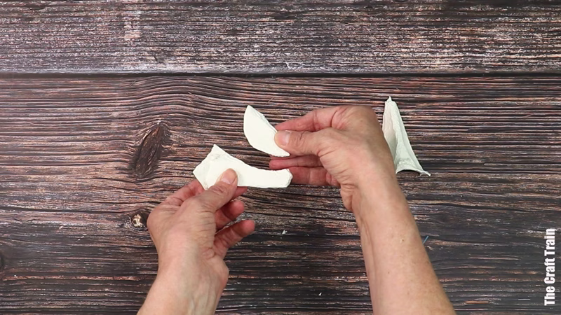 Hands showing how to make an egg carton peace dove ornament