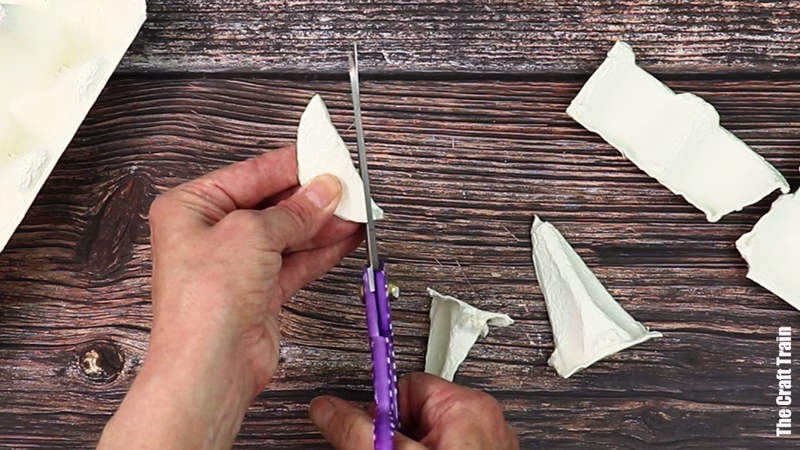 Hands showing how to make an egg carton peace dove ornament