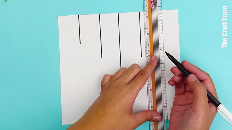 Potato stamp Christmas bauble artwork steps - use a ruler and black marker to draw lines on the page