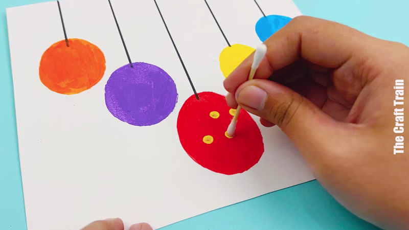 Q-tip dots being added to potato stamp bauble art