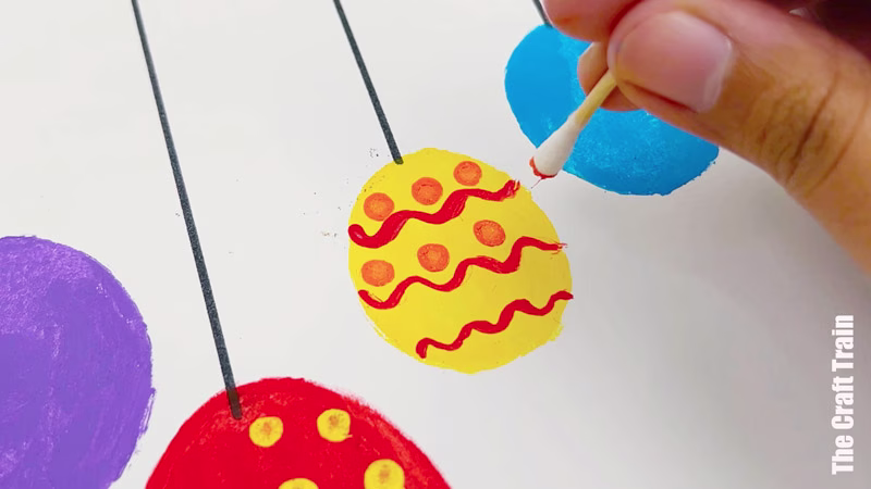 Potato stamp Christmas bauble artwork steps - use a q-tip to draw patterns on your Christmas bauble artwork